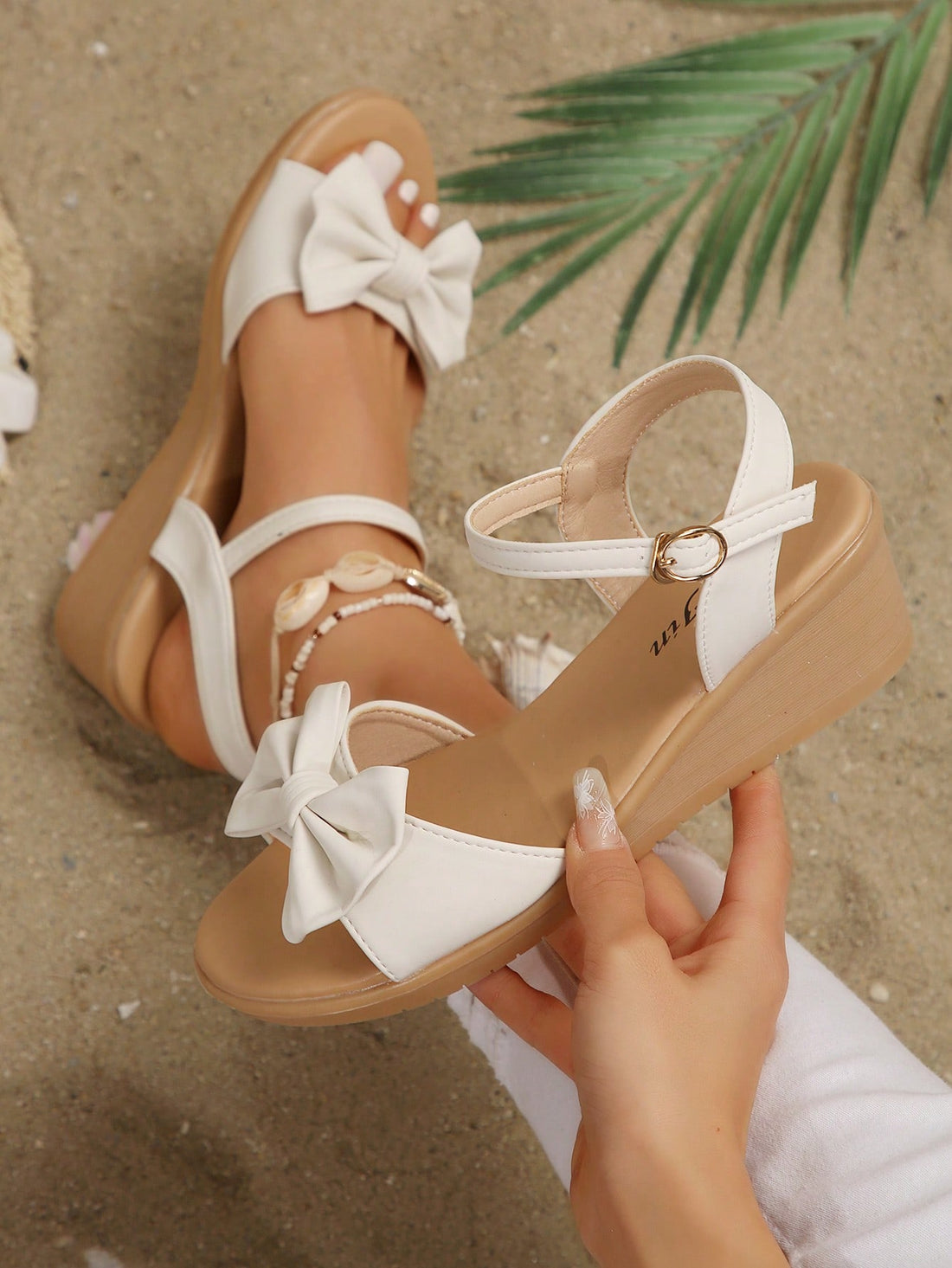 Women's open-toe wedge sandals featuring a thick sole, mid wedge heel, bowknot detail, and single buckle ankle strap.