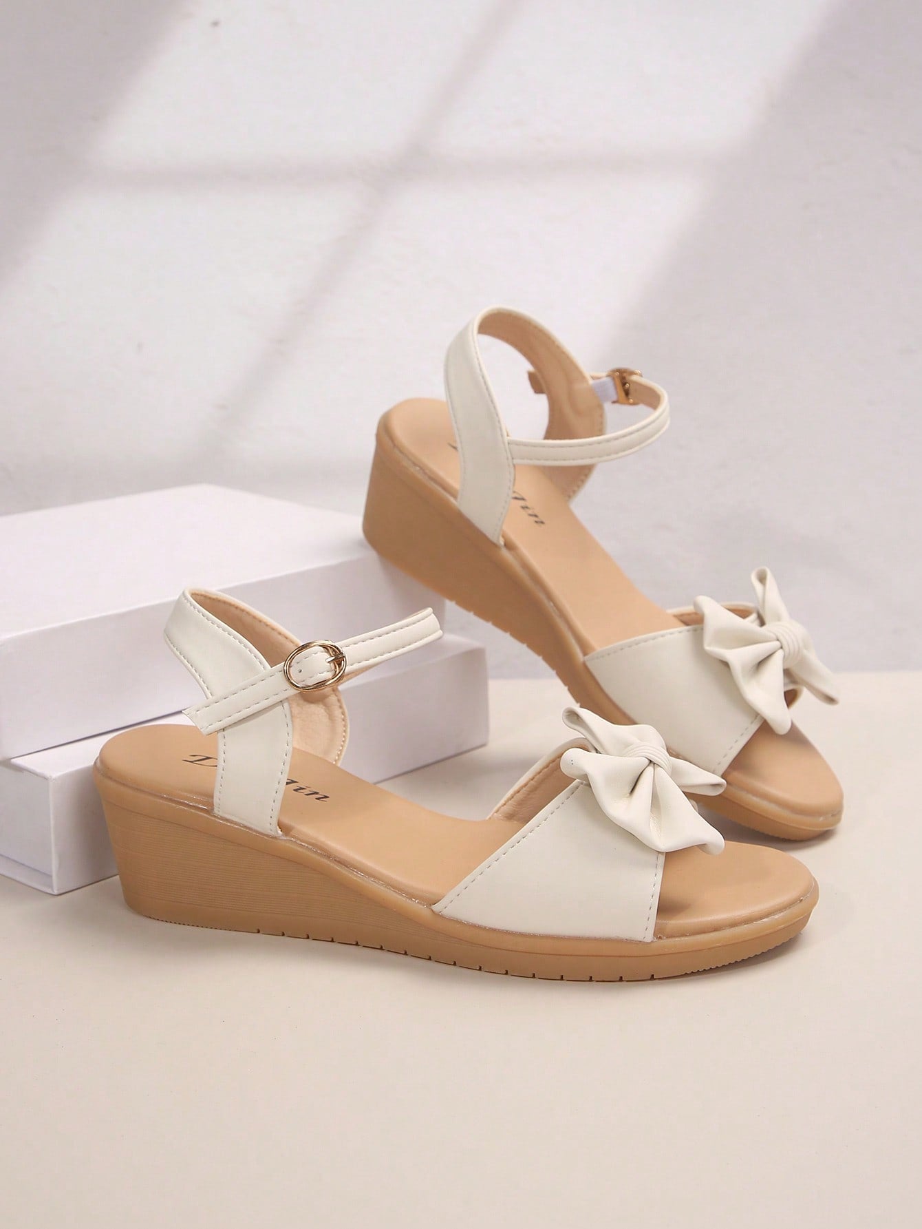 Women's open-toe wedge sandals featuring a thick sole, mid wedge heel, bowknot detail, and single buckle ankle strap.