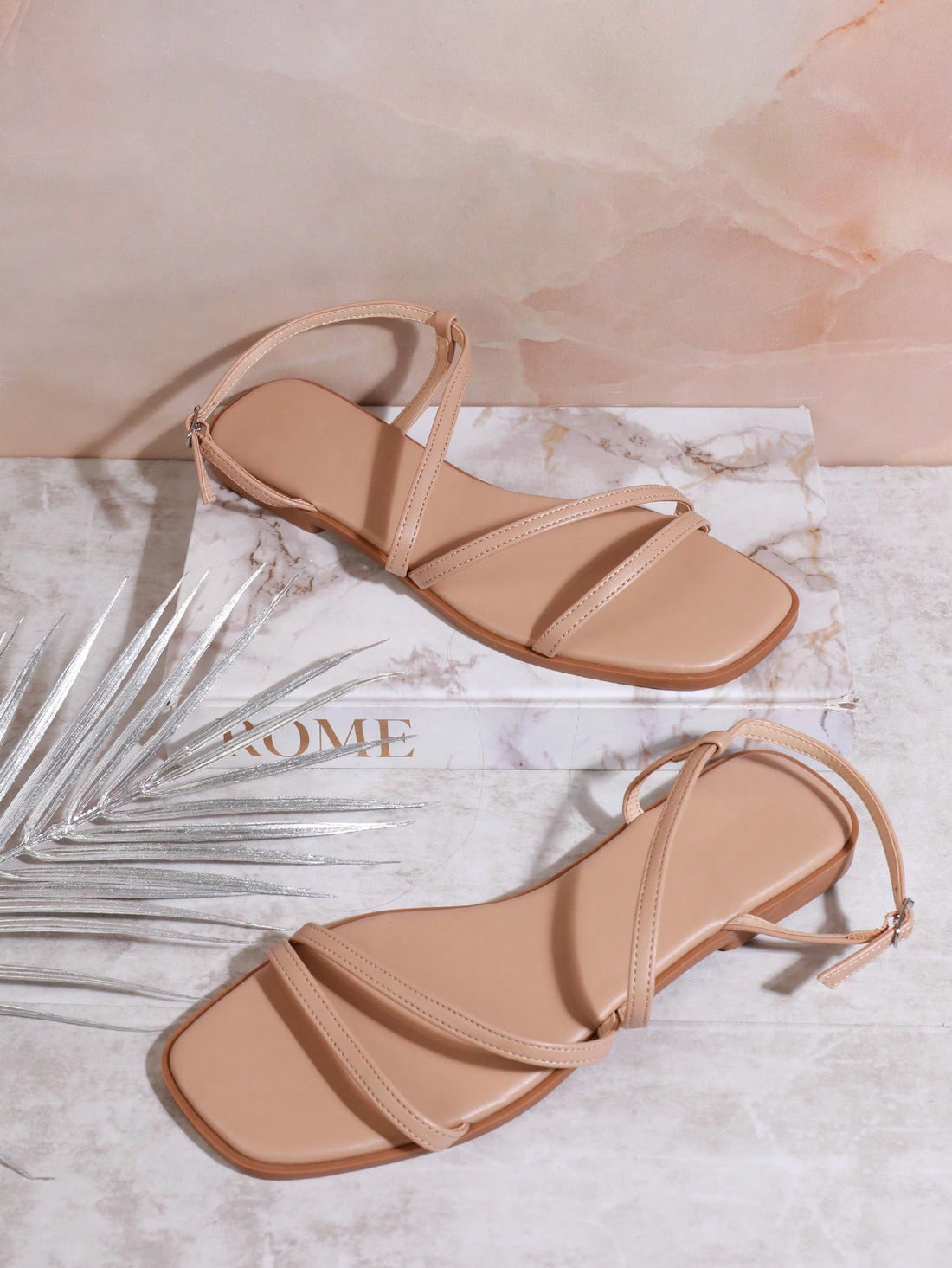 Women's flat open-toe sandals featuring a buckle detail and PU leather construction with a flat sole.
