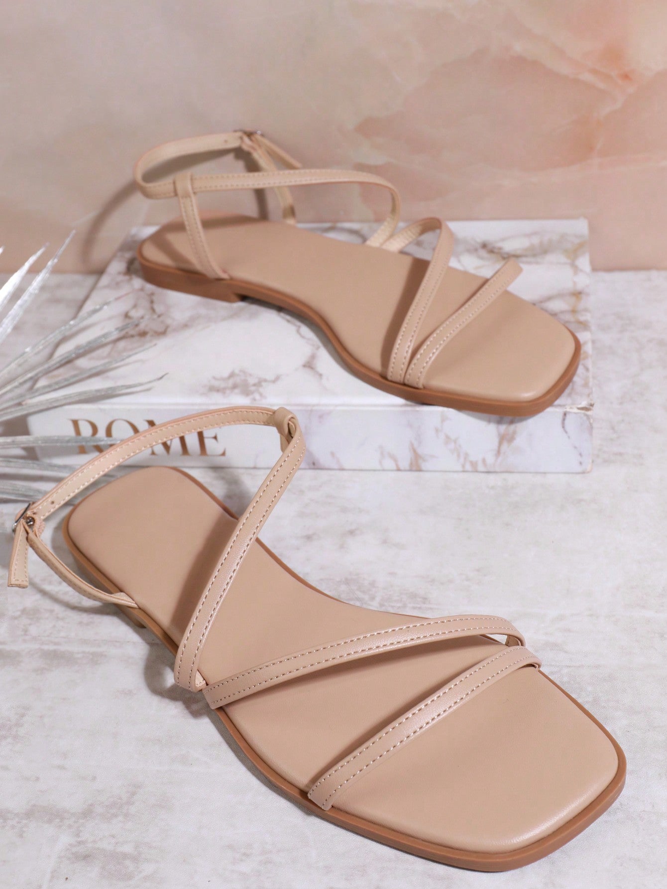 Women's flat open-toe sandals featuring a buckle detail and PU leather construction with a flat sole.