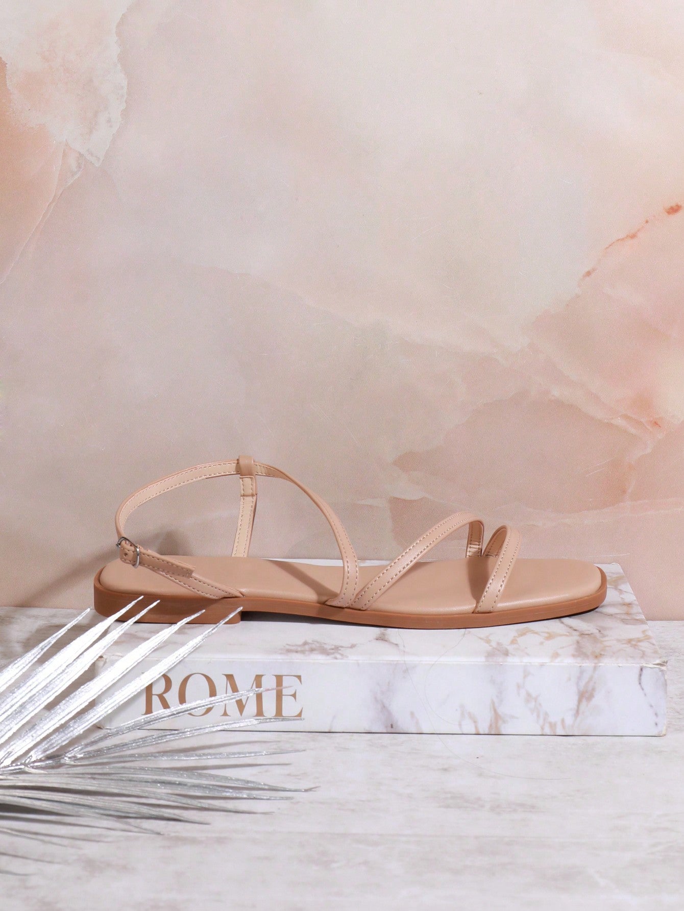 Women's flat open-toe sandals featuring a buckle detail and PU leather construction with a flat sole.