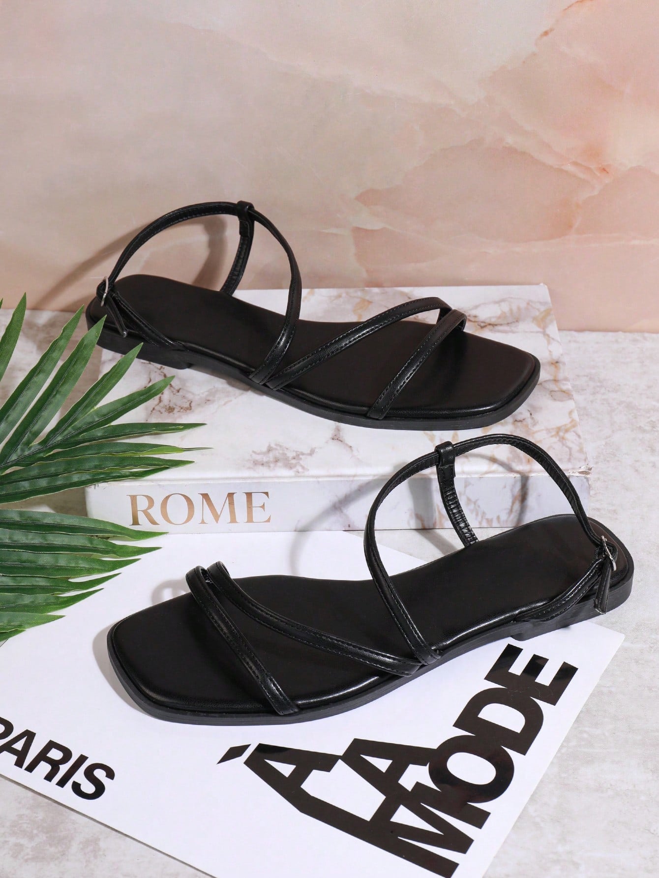 Women's flat open-toe sandals featuring a buckle detail and PU leather construction with a flat sole.