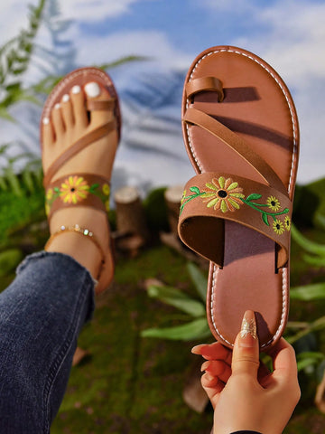 Women's mocha brown flat toe-post flip flops with sunflower design, woven slingback strap, and buckle chain detail, styled as comfortable beach sandals.