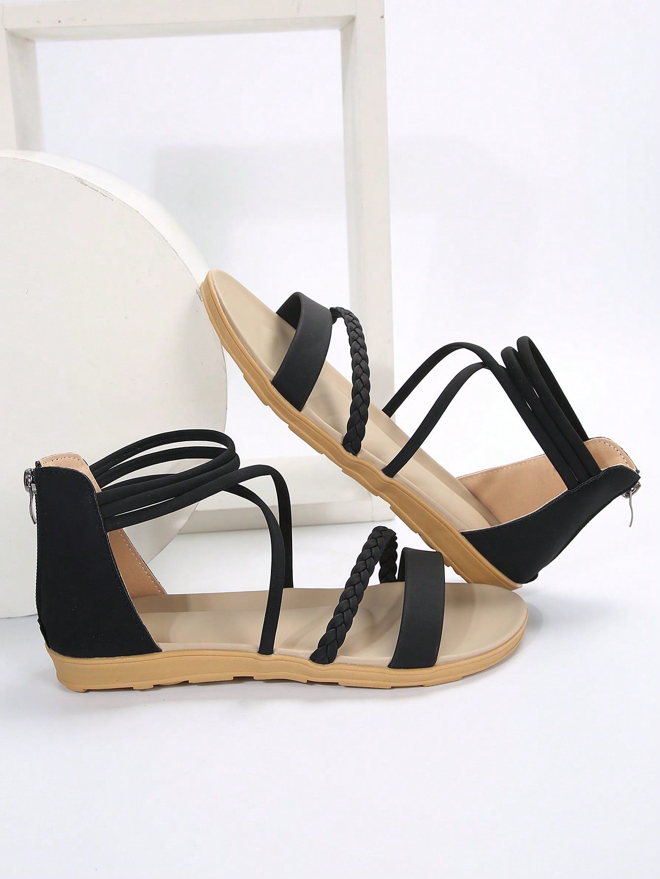 Women’s flat gladiator sandals with braided detail and an open-toe design, suitable for beach and outdoor wear.