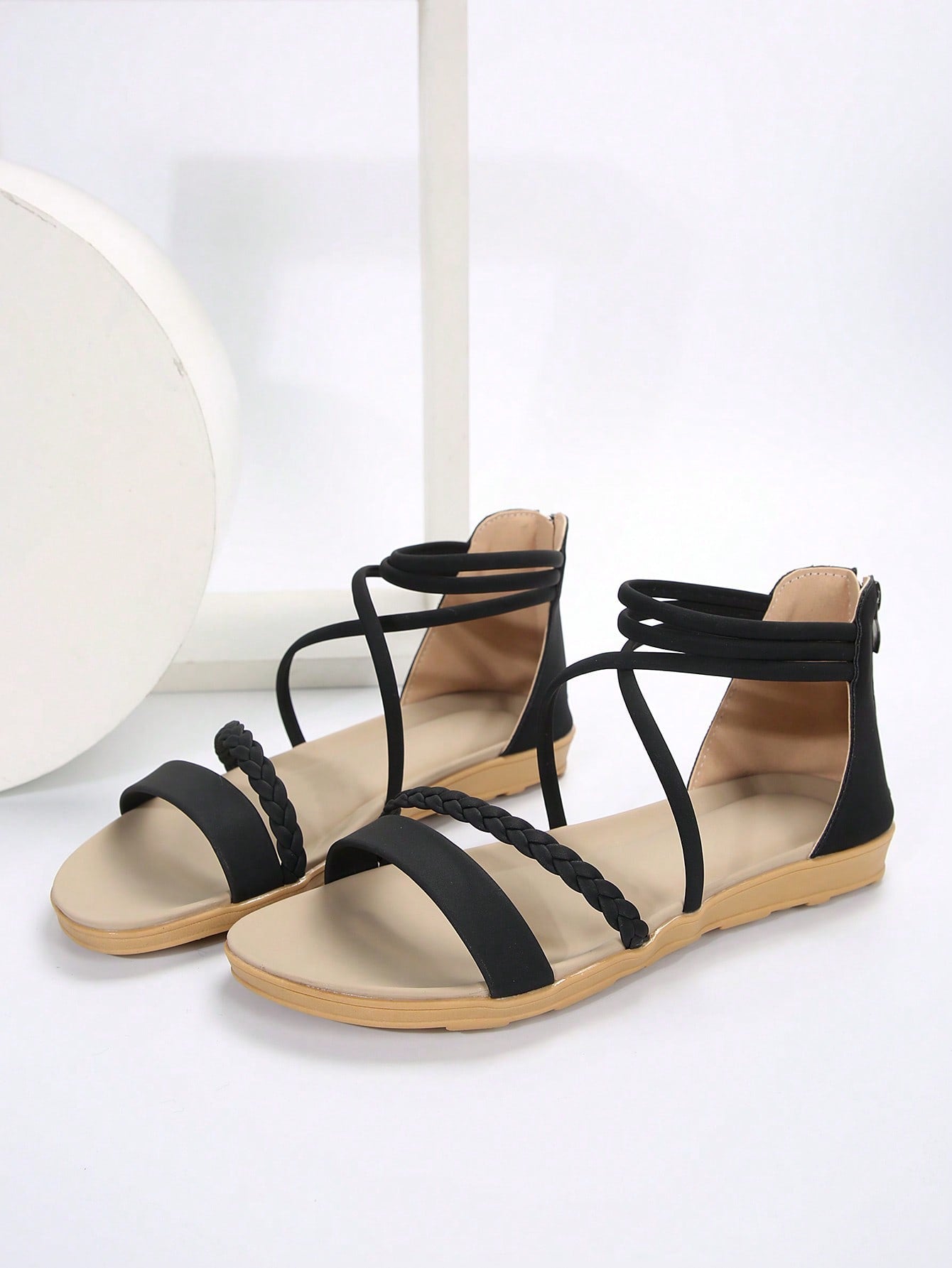 Women’s flat gladiator sandals with braided detail and an open-toe design, suitable for beach and outdoor wear.