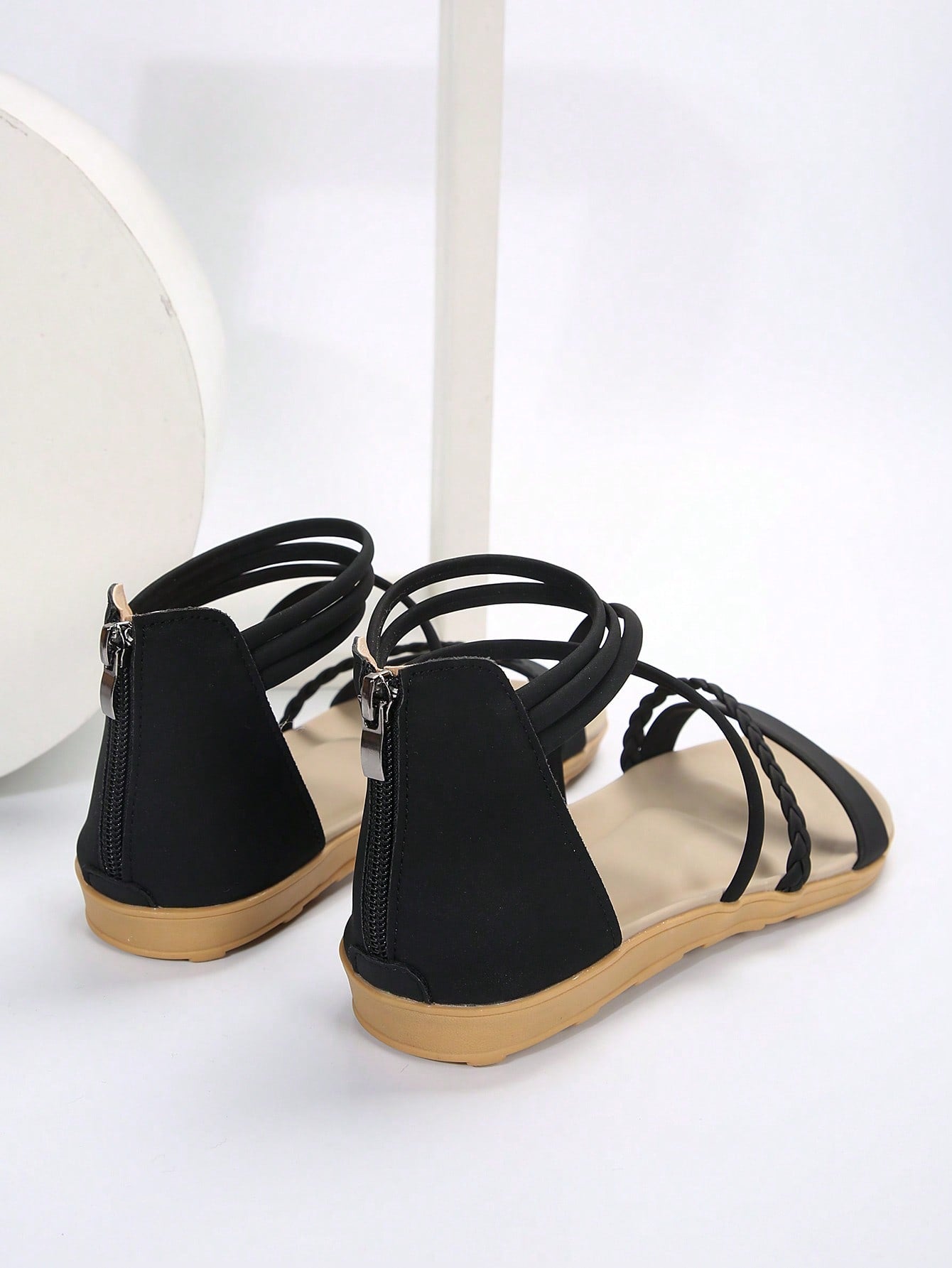 Women’s flat gladiator sandals with braided detail and an open-toe design, suitable for beach and outdoor wear.