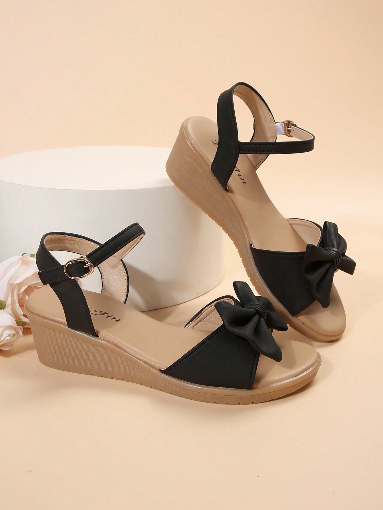 Women's open-toe wedge sandals featuring a thick sole, mid wedge heel, bowknot detail, and single buckle ankle strap.