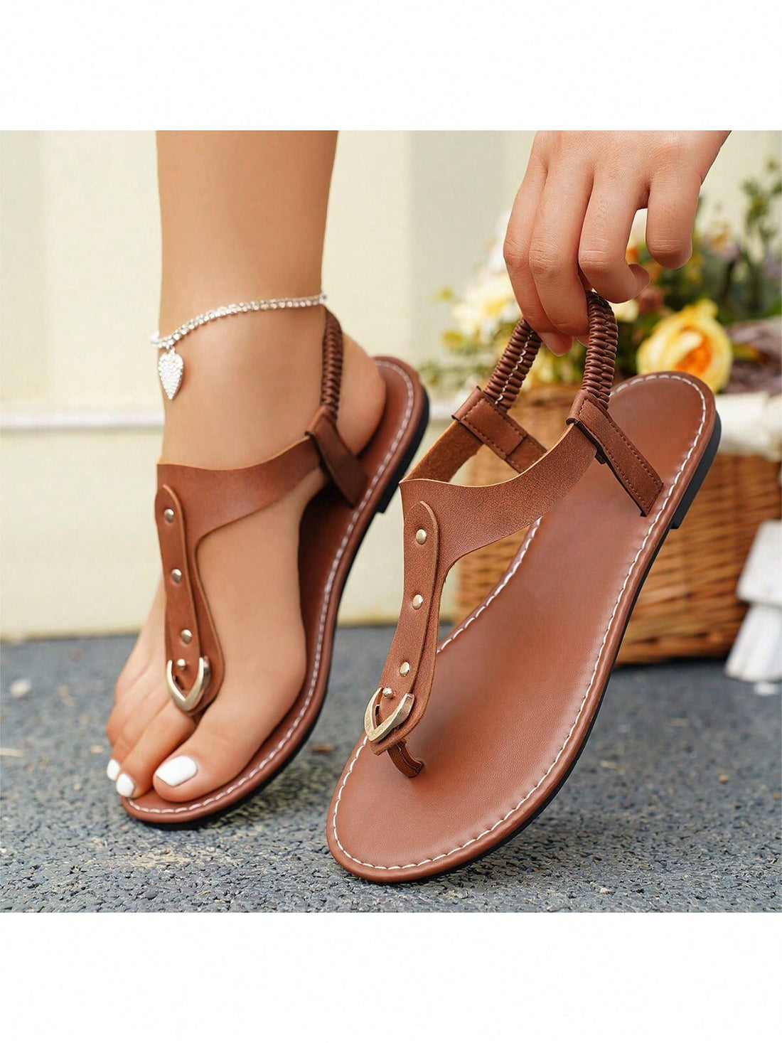 Women's flat slide sandals with rivet decor, elastic strap, buckle detail, and toe post open design for outdoor and beach wear.