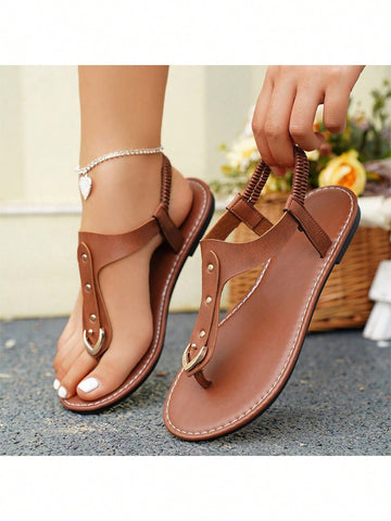 Women's flat slide sandals with rivet decor, elastic strap, buckle detail, and toe post open design for outdoor and beach wear.