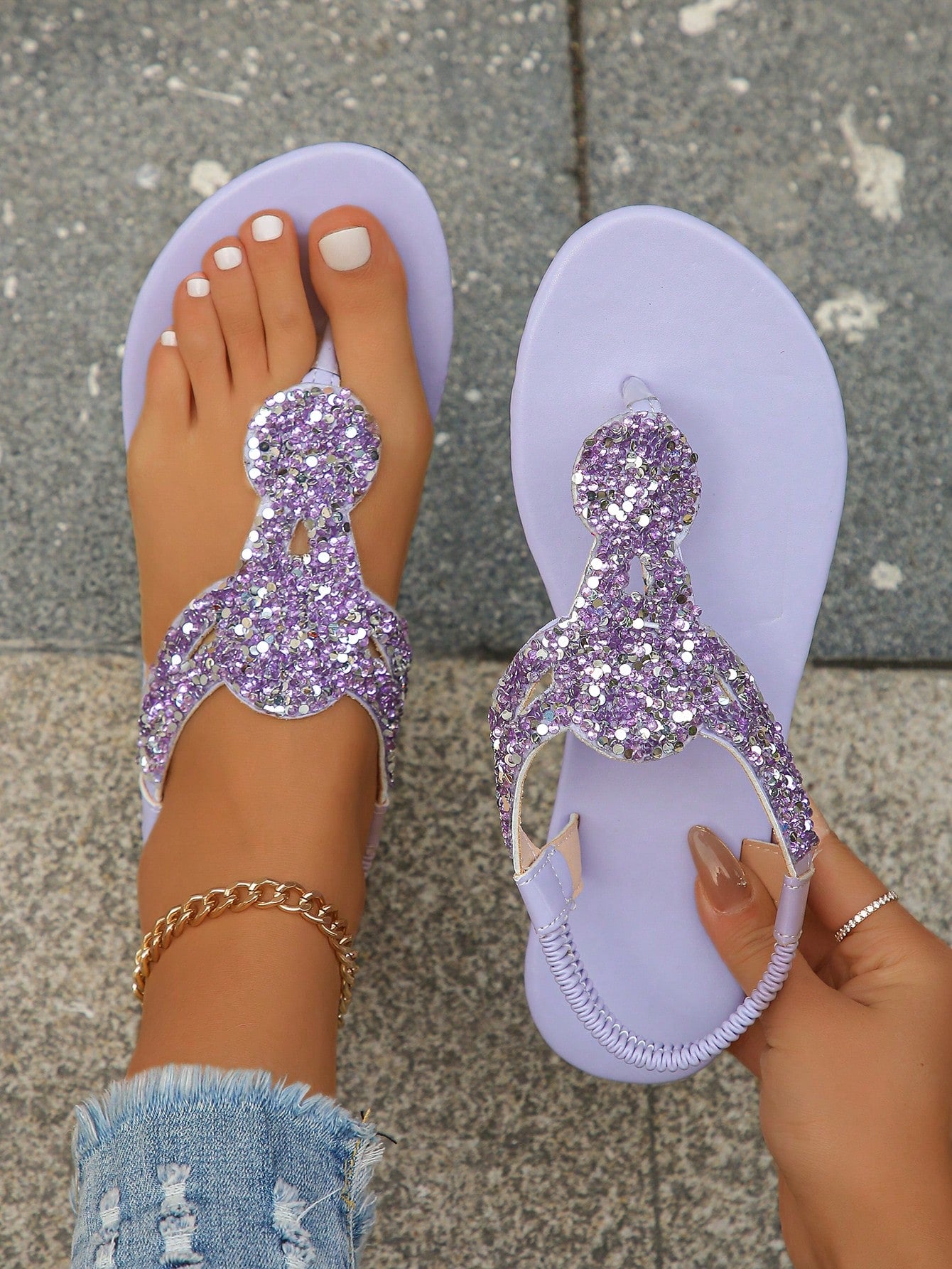 Women’s plus size 35-45 flat thong sandals with elastic strap, round toe shape, textured pattern, and rhinestone asymmetrical detail in slip-on beach style for outdoor summer wear.