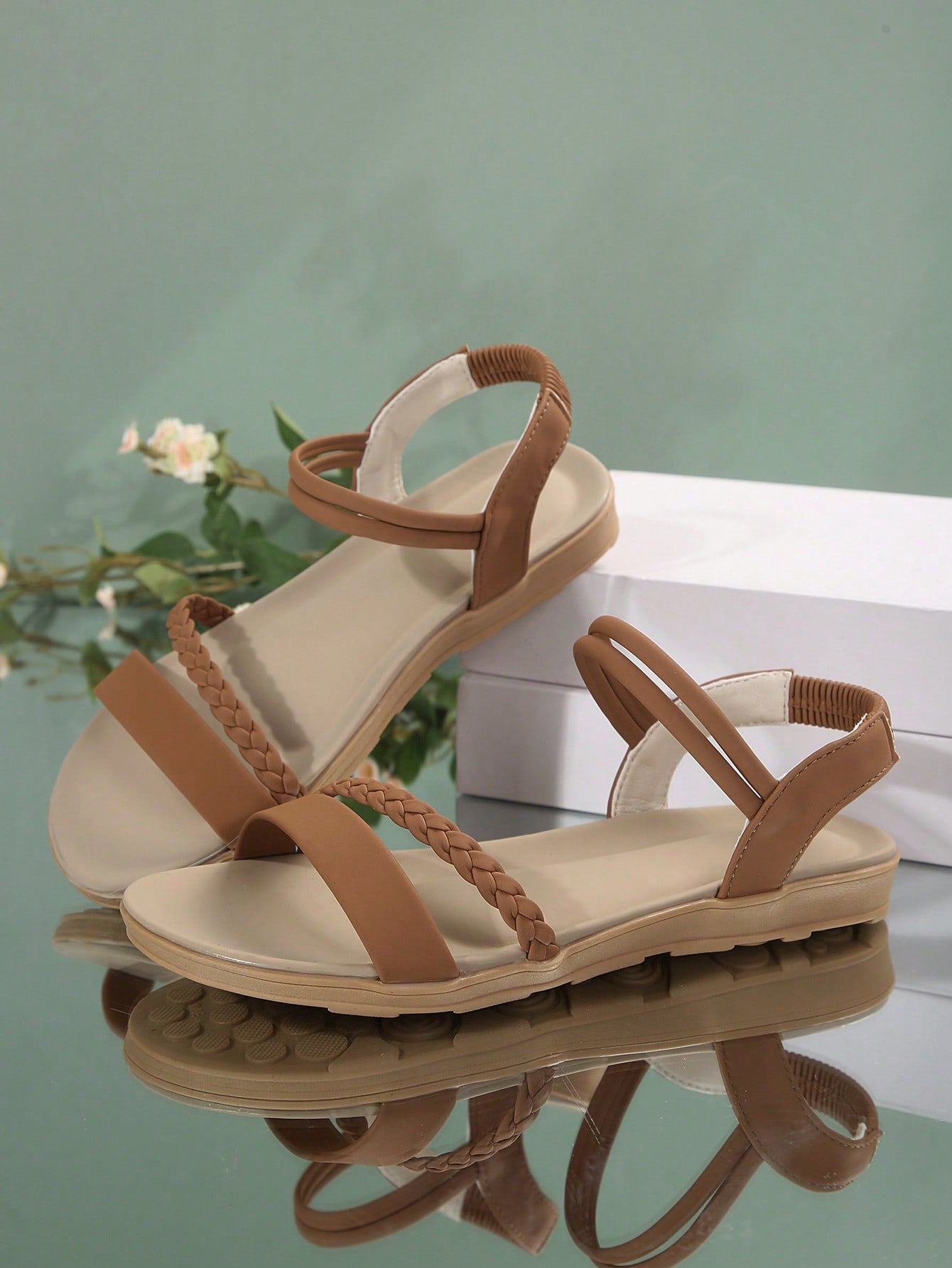 Women’s flat gladiator sandals with braided detail and an open-toe design, suitable for beach and outdoor wear.