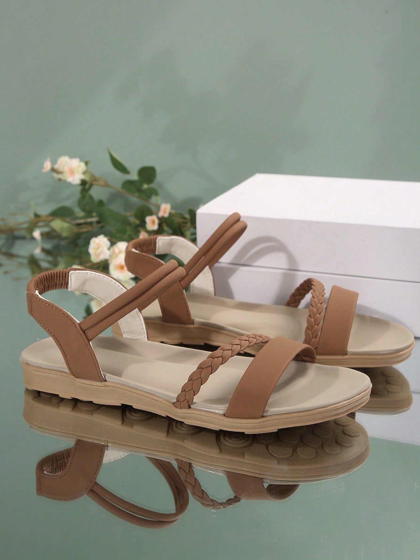 Women’s flat gladiator sandals with braided detail and an open-toe design, suitable for beach and outdoor wear.