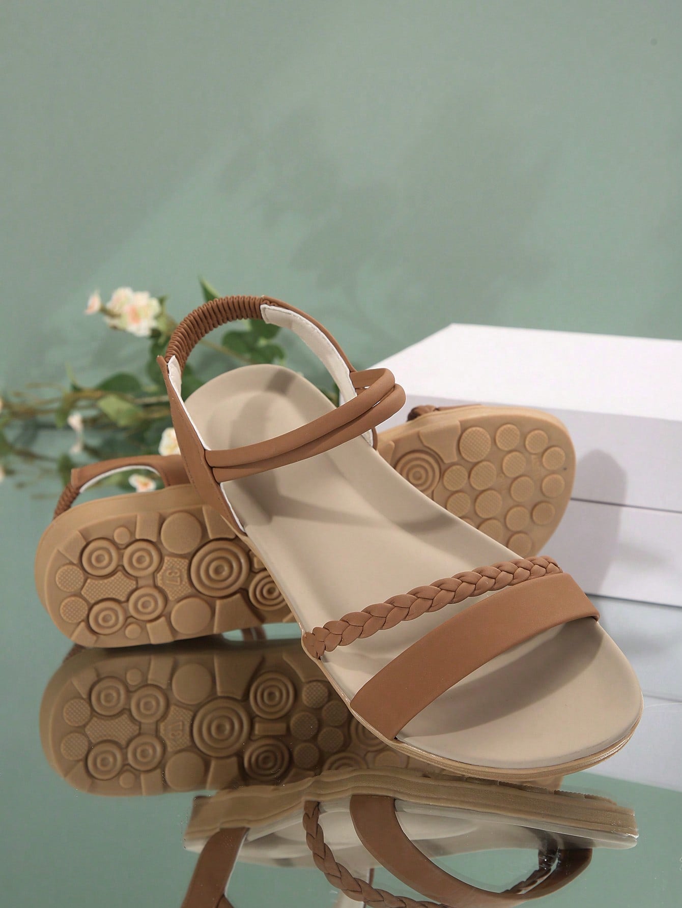 Women’s flat gladiator sandals with braided detail and an open-toe design, suitable for beach and outdoor wear.