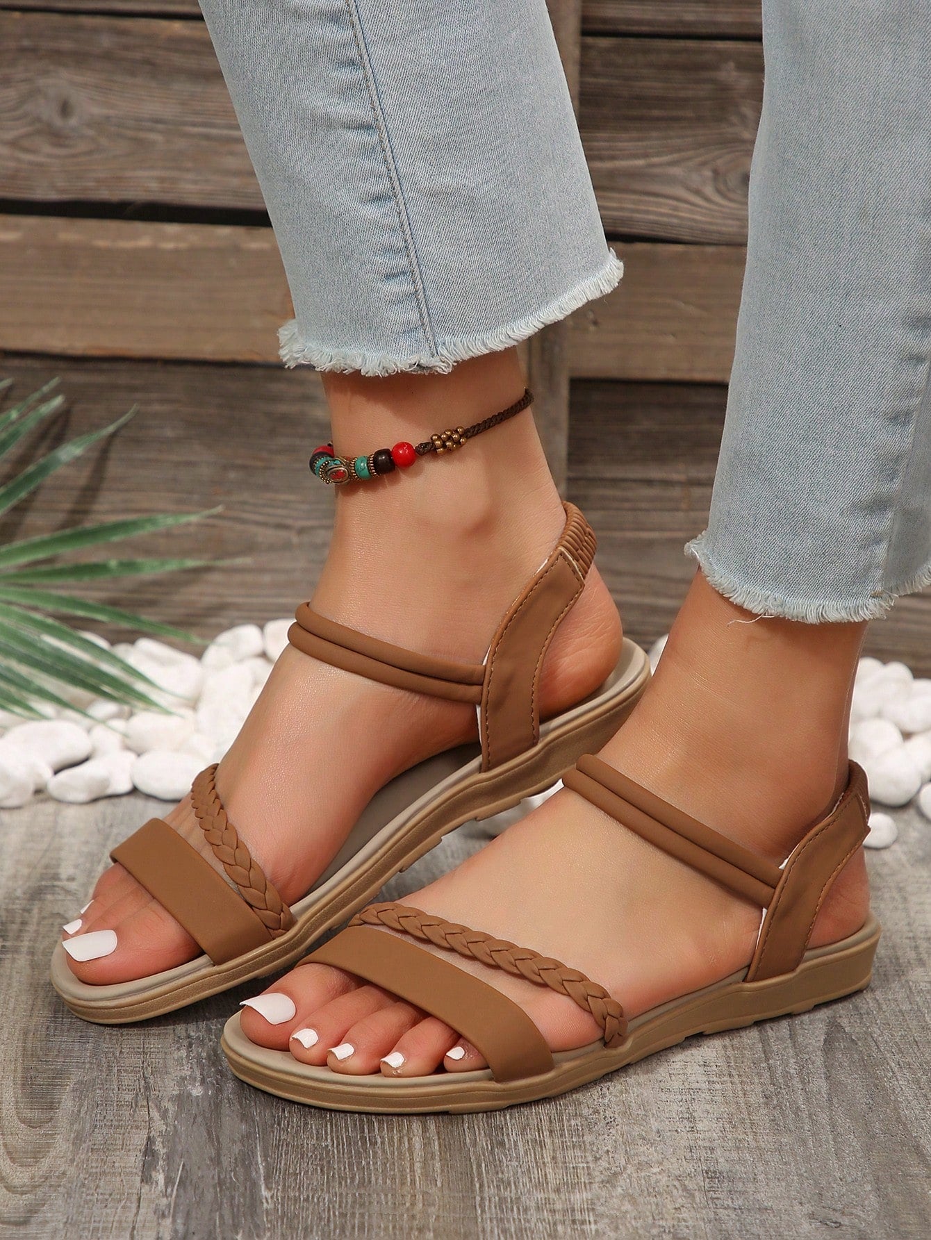 Women’s flat gladiator sandals with braided detail and an open-toe design, suitable for beach and outdoor wear.