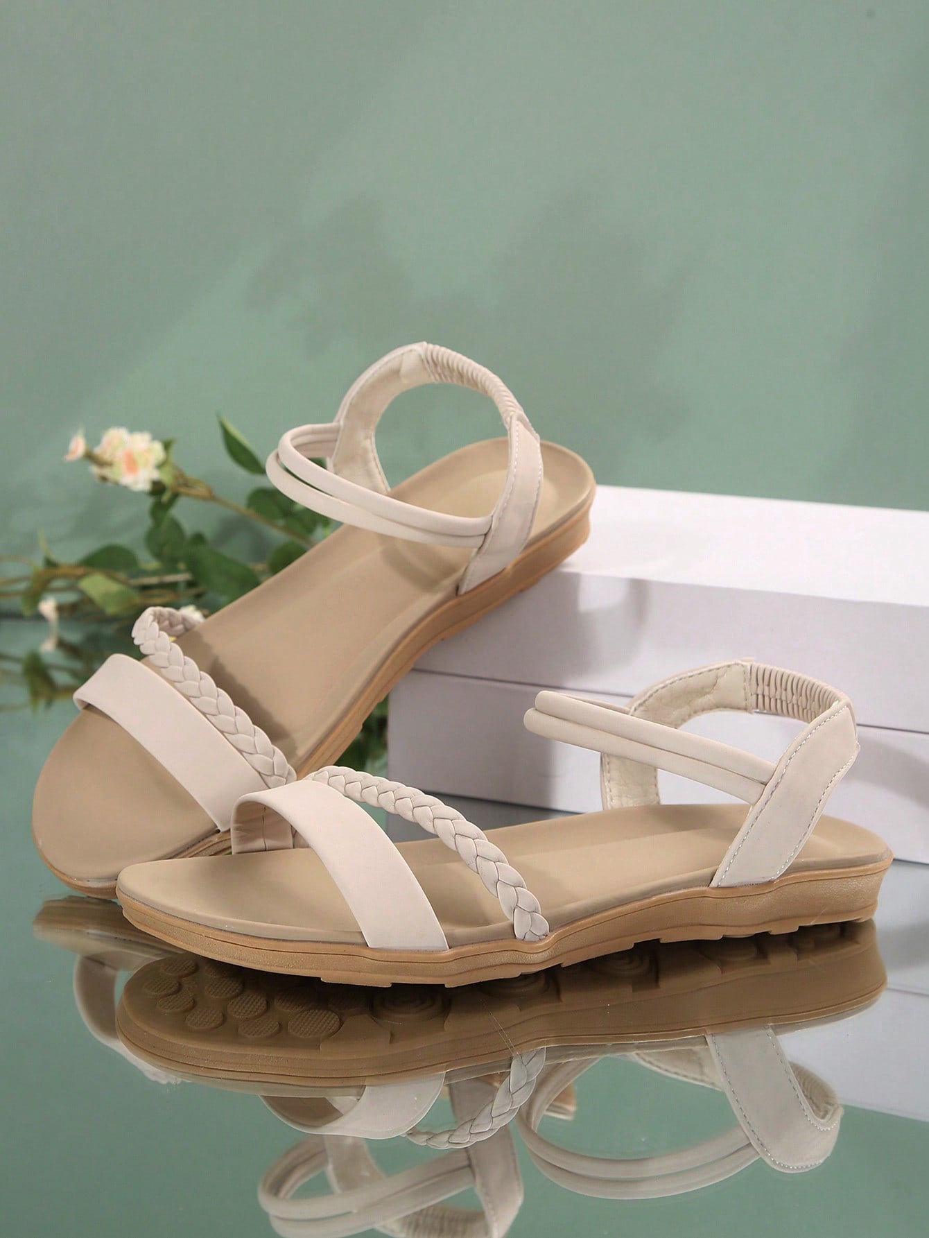 Women’s flat gladiator sandals with braided detail and an open-toe design, suitable for beach and outdoor wear.