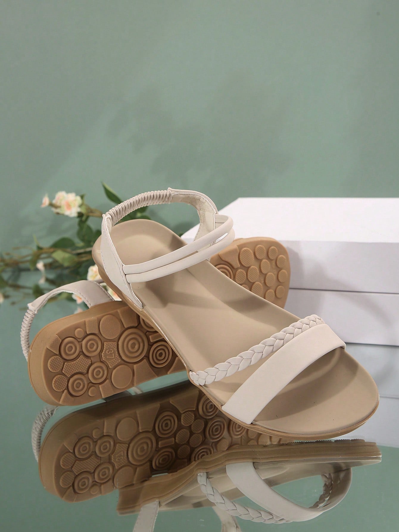 Women’s flat gladiator sandals with braided detail and an open-toe design, suitable for beach and outdoor wear.
