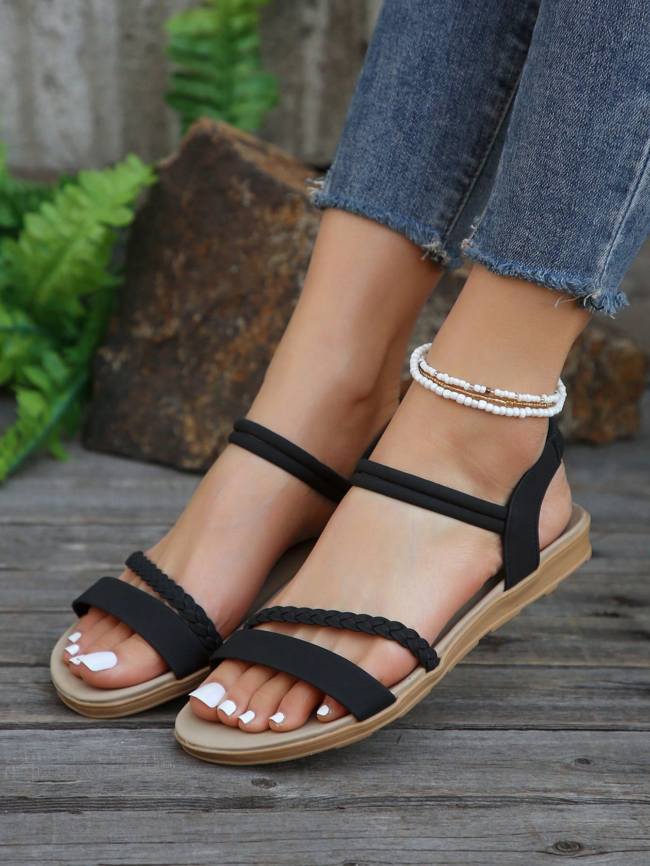 Women’s flat gladiator sandals with braided detail and an open-toe design, suitable for beach and outdoor wear.