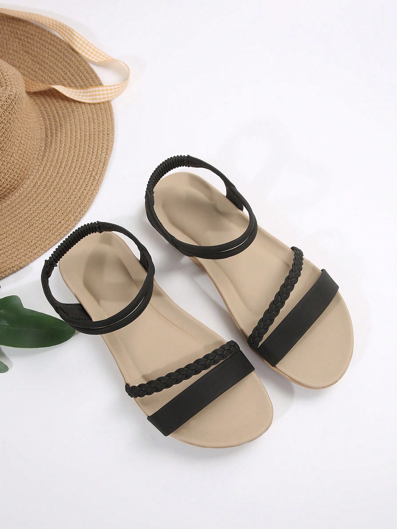 Women’s flat gladiator sandals with braided detail and an open-toe design, suitable for beach and outdoor wear.