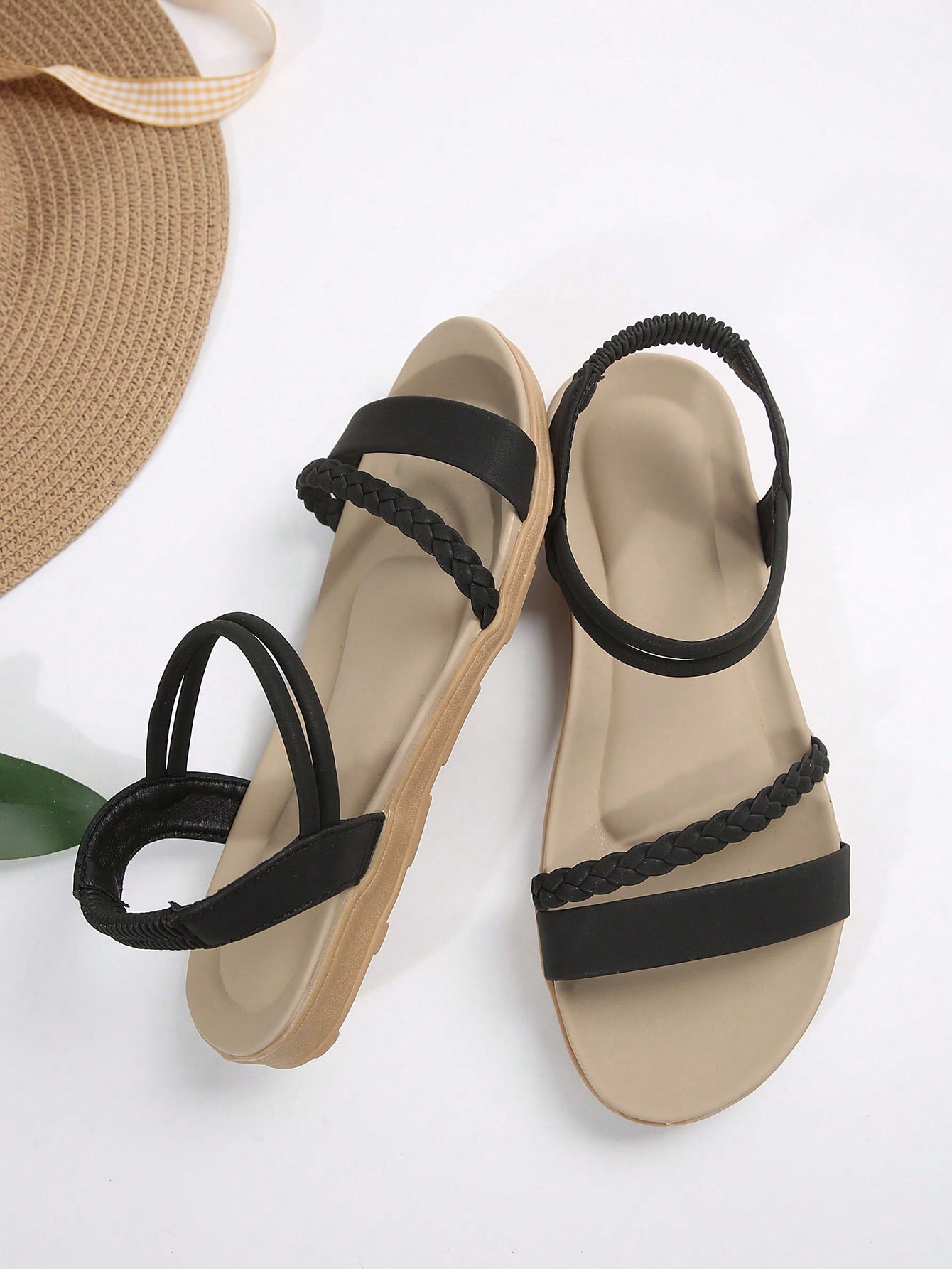 Women’s flat gladiator sandals with braided detail and an open-toe design, suitable for beach and outdoor wear.