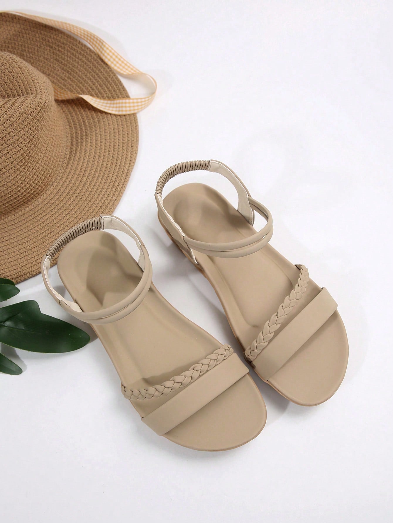 Women’s flat gladiator sandals with braided detail and an open-toe design, suitable for beach and outdoor wear.