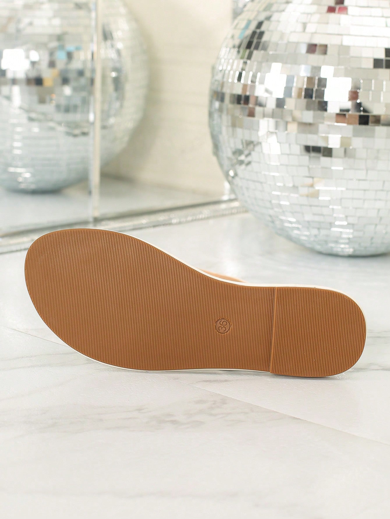 Women's slip-on flat sandals featuring round toe styling, a toe post, metal strap detail, and buckle accent, designed for casual beach and warm-weather outfits.