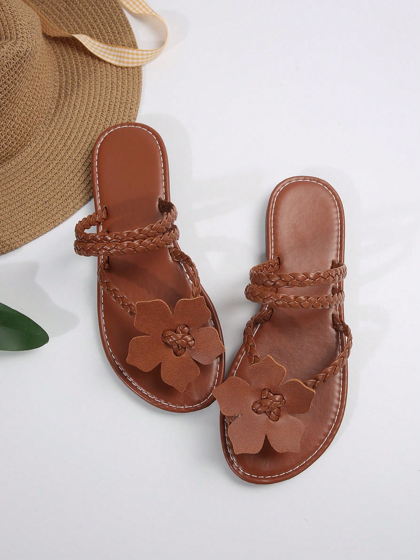 Women's brown floral print flat slide sandals with braided detail and toe-post design, casual beach-ready summer slippers.