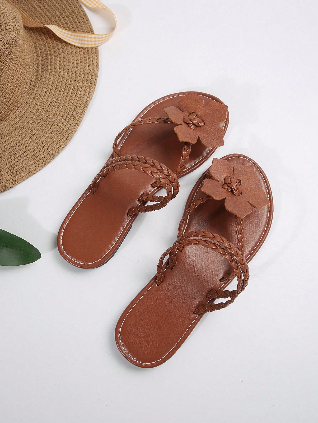 Women's brown floral print flat slide sandals with braided detail and toe-post design, casual beach-ready summer slippers.