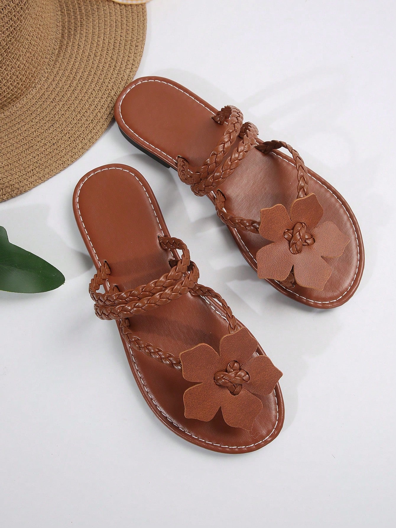 Women's brown floral print flat slide sandals with braided detail and toe-post design, casual beach-ready summer slippers.