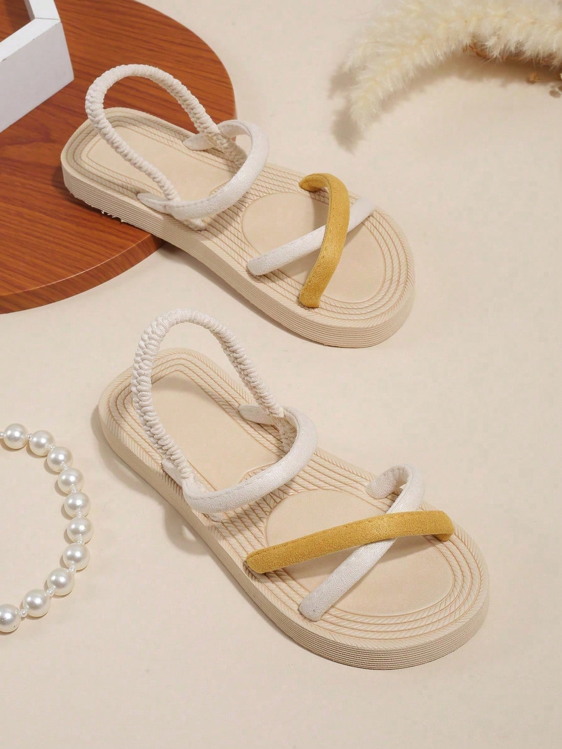 Women's colorblock flat slide sandals with criss cross strap, toe post, cloth tape and fleece detail, finished with sequin, crystal, gemstone, and knot accents.