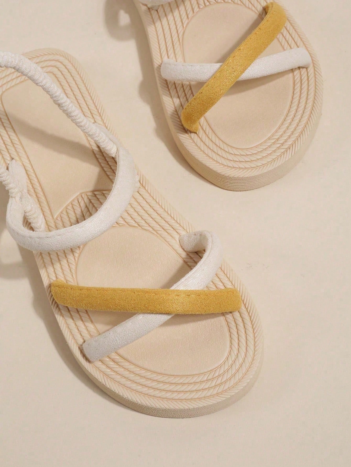 Women's colorblock flat slide sandals with criss cross strap, toe post, cloth tape and fleece detail, finished with sequin, crystal, gemstone, and knot accents.
