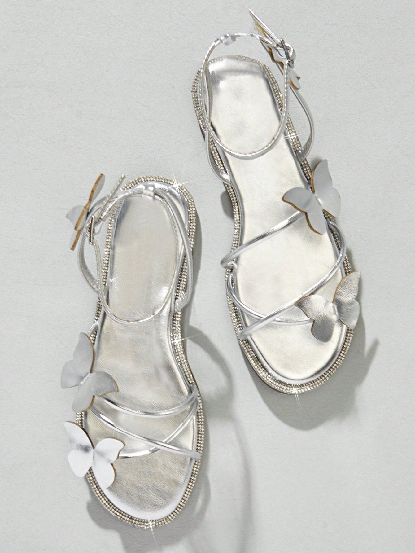 Women's flat open-toe sandals featuring a buckle detail and PU leather construction with a flat sole.