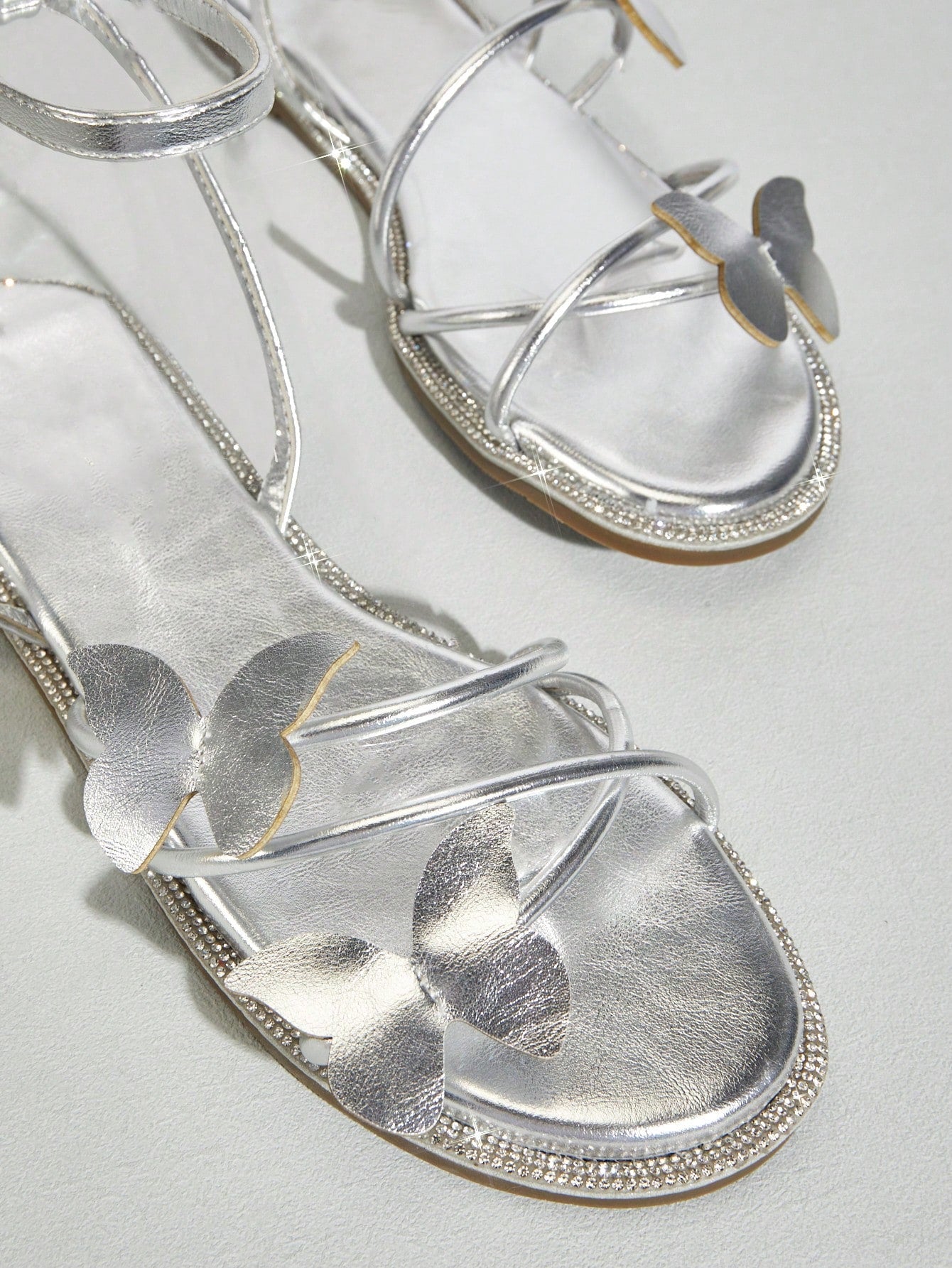 Women's flat open-toe sandals featuring a buckle detail and PU leather construction with a flat sole.