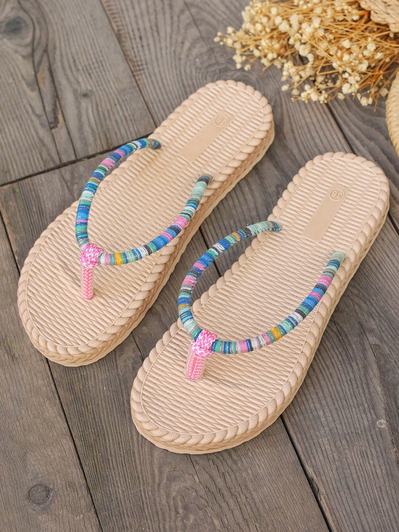 Women's flat slide sandals with asymmetrical design, lightweight construction, and breathable faux rope-style sole detail for vacation and beach wear.