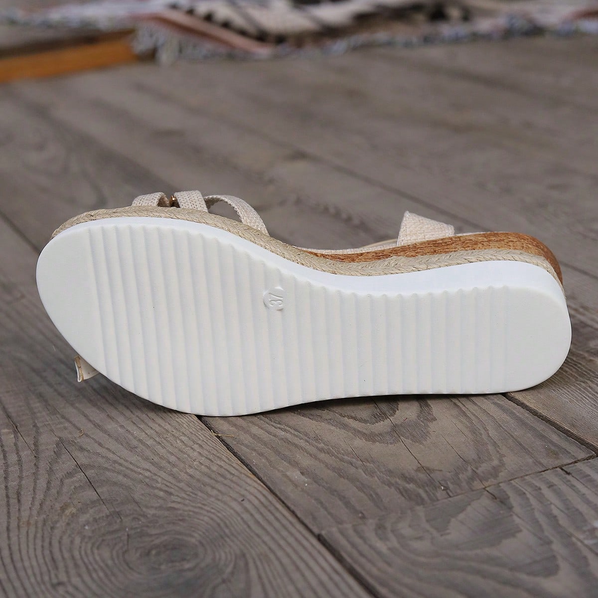 Women’s open-toe wedge sandals with a woven platform-style sole, ankle buckle strap, and mid heel, shown in a casual outdoor style.