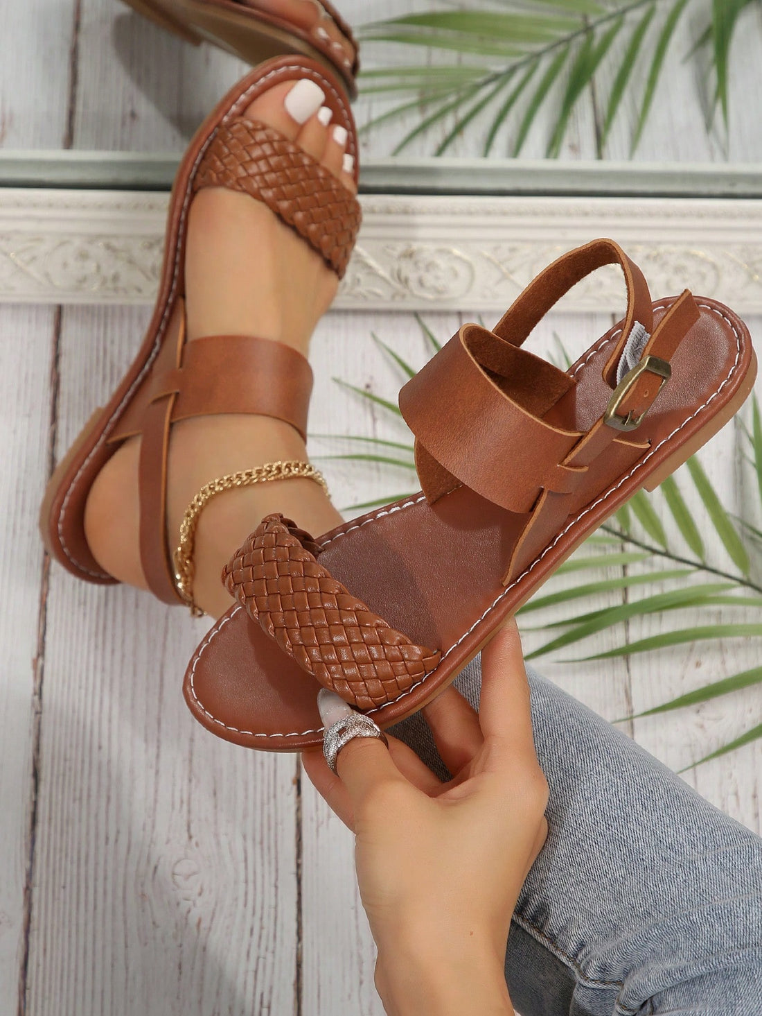 Pair of women’s coffee brown flat sandals with woven braid straps, open toe design, and buckle closure, suitable for casual beach outfits.
