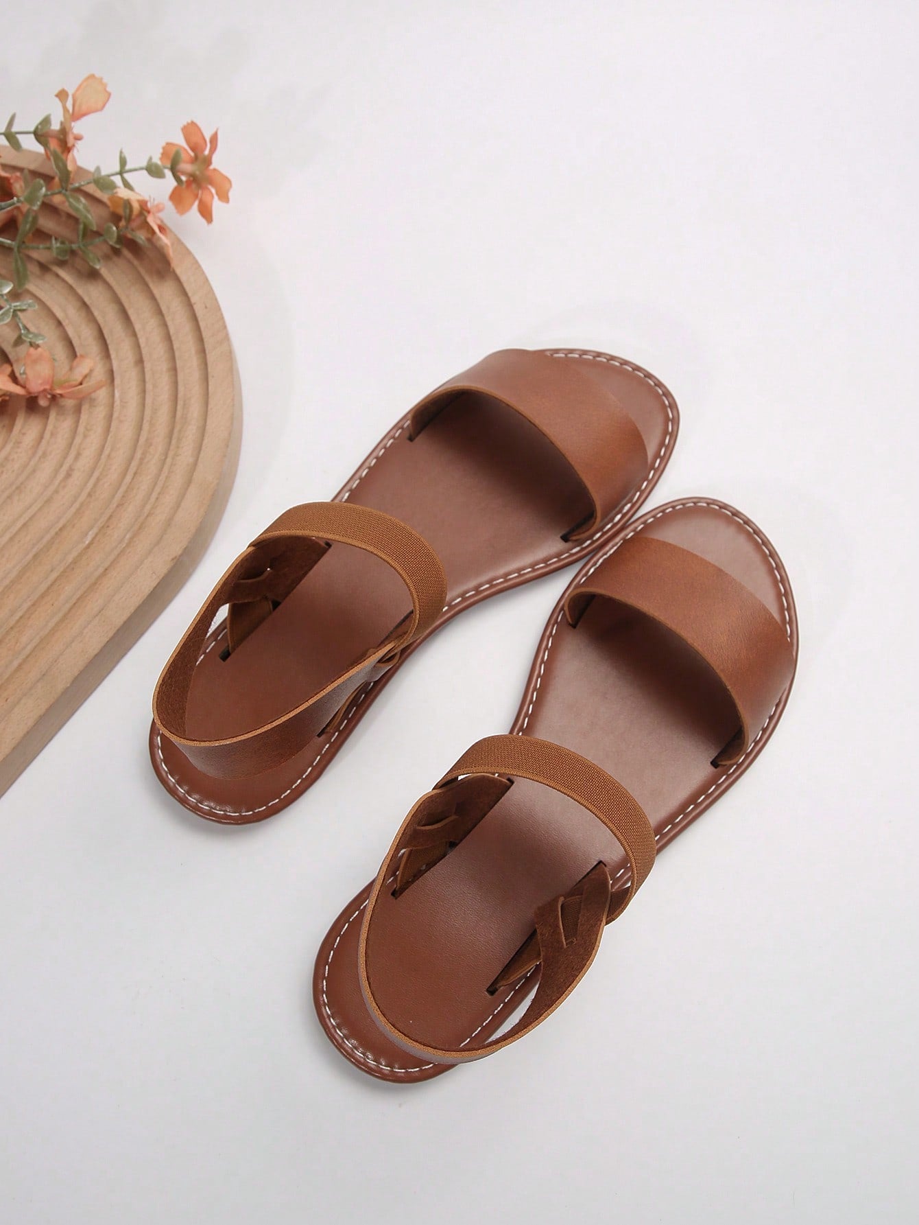 Women’s flat slide sandals with cut-out Roman-style straps and open-toe design, suitable for casual beach and home wear.