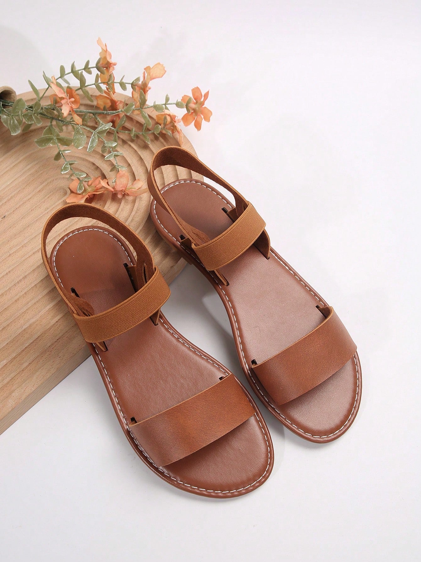 Women’s flat slide sandals with cut-out Roman-style straps and open-toe design, suitable for casual beach and home wear.