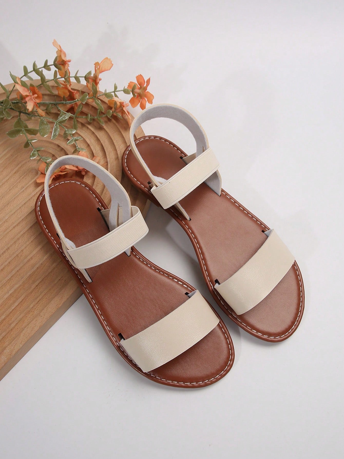 Women’s flat slide sandals with cut-out Roman-style straps and open-toe design, suitable for casual beach and home wear.