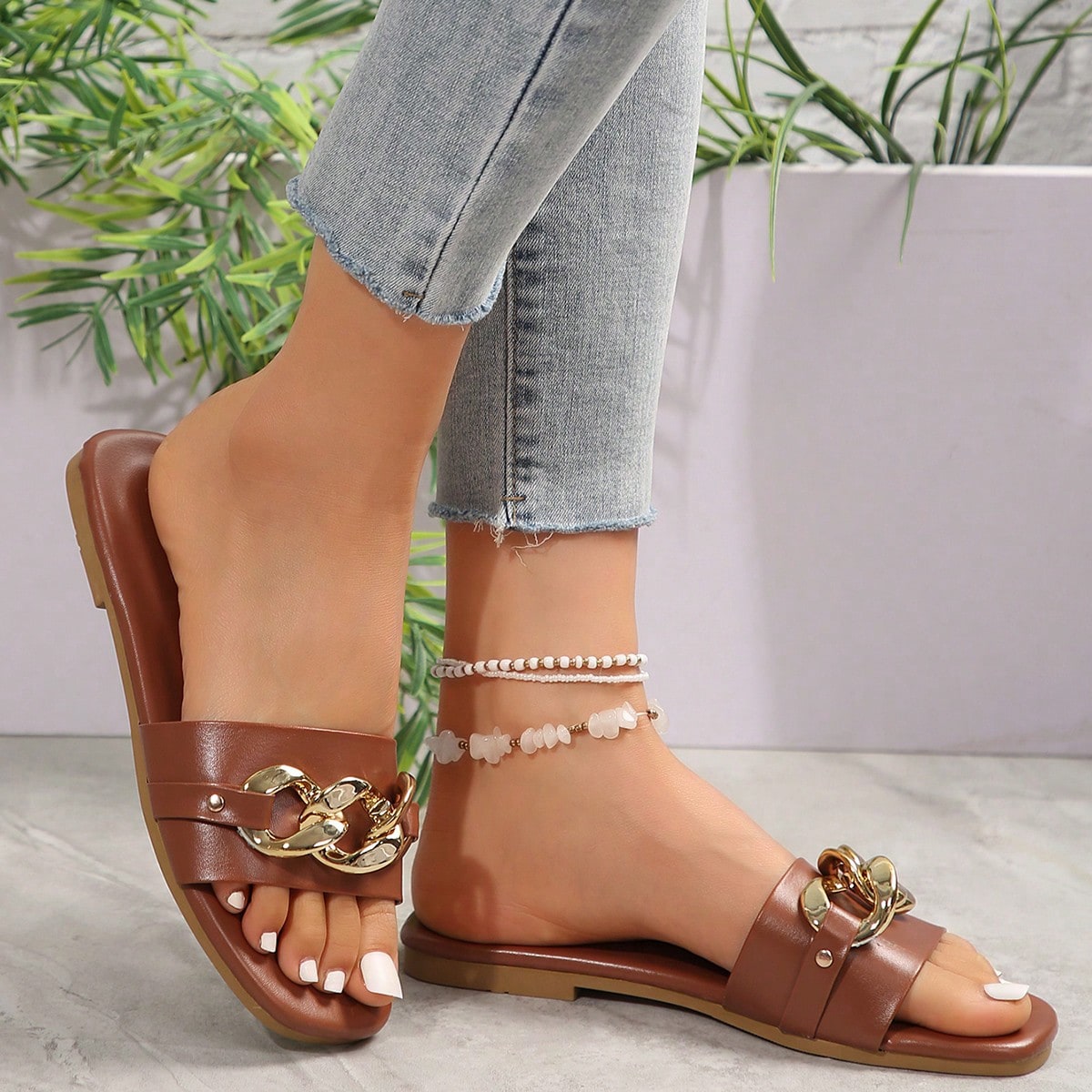Women's gold-tone slip-on slide sandals with open toe and chain link detailing, shown as casual flat sandals for indoor and outdoor use.