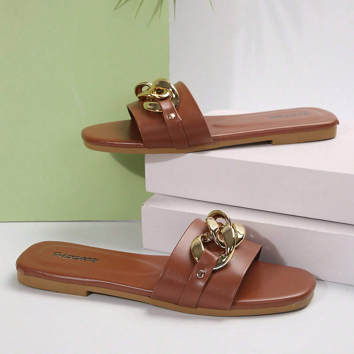 Women's gold-tone slip-on slide sandals with open toe and chain link detailing, shown as casual flat sandals for indoor and outdoor use.