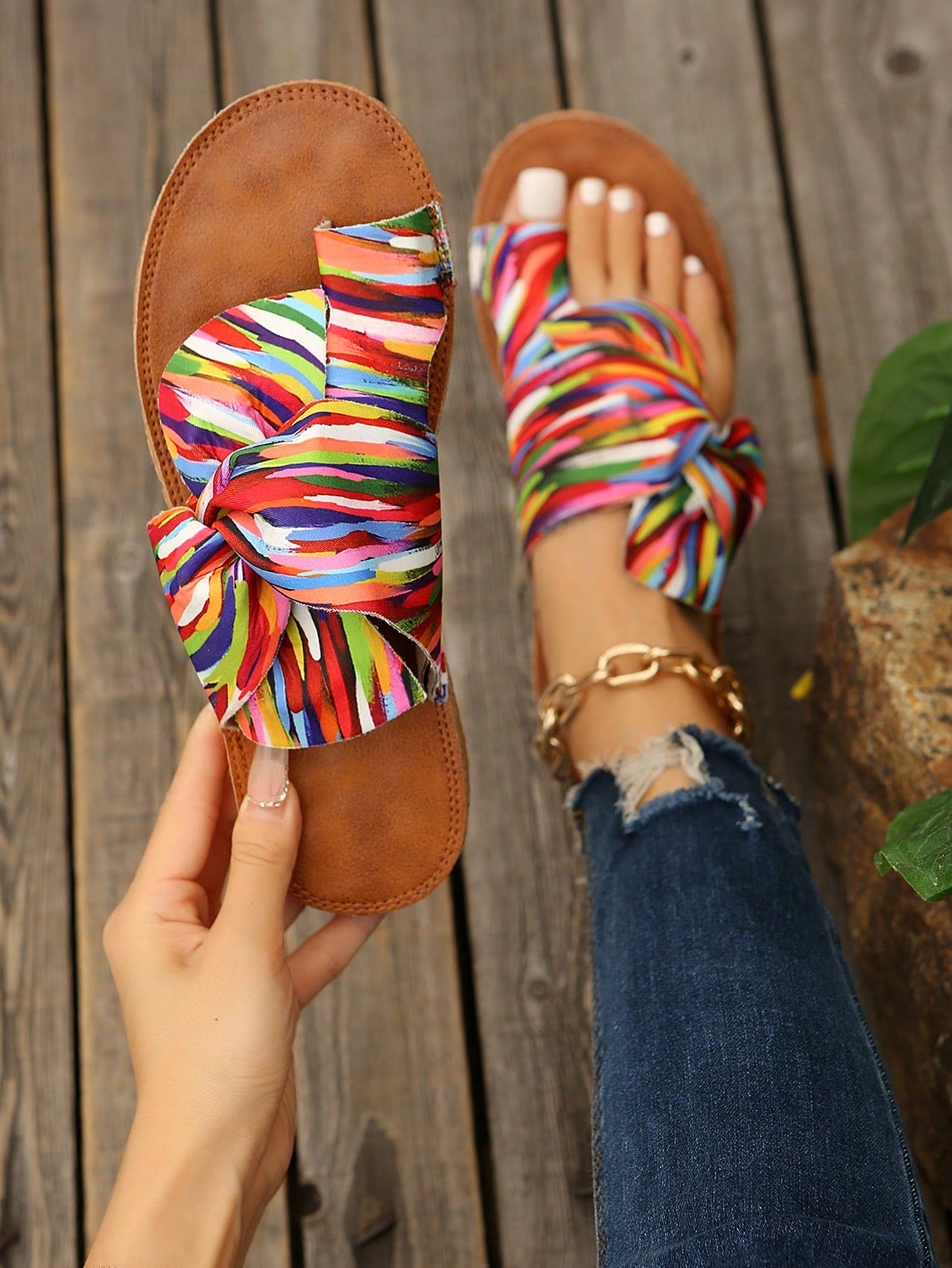 Women's flat slide sandals with bow tie, knot, and braided details, toe post design, and bohemian plant pattern.