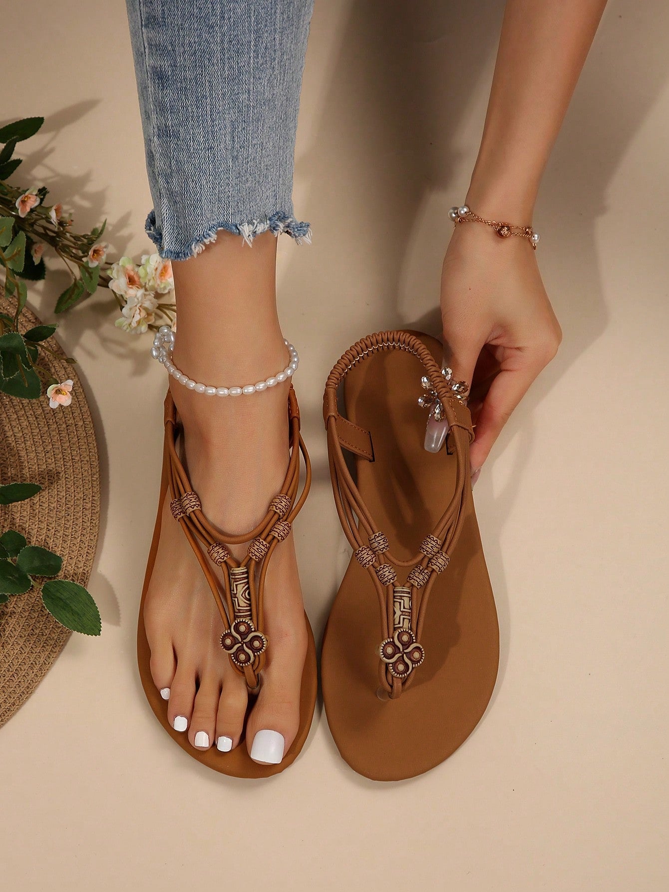 Women's flat gladiator sandals with beaded toe ring and toe post, designed for beach and vacation outfits.