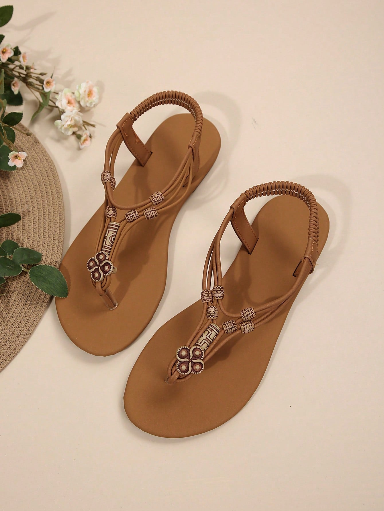 Women's flat gladiator sandals with beaded toe ring and toe post, designed for beach and vacation outfits.