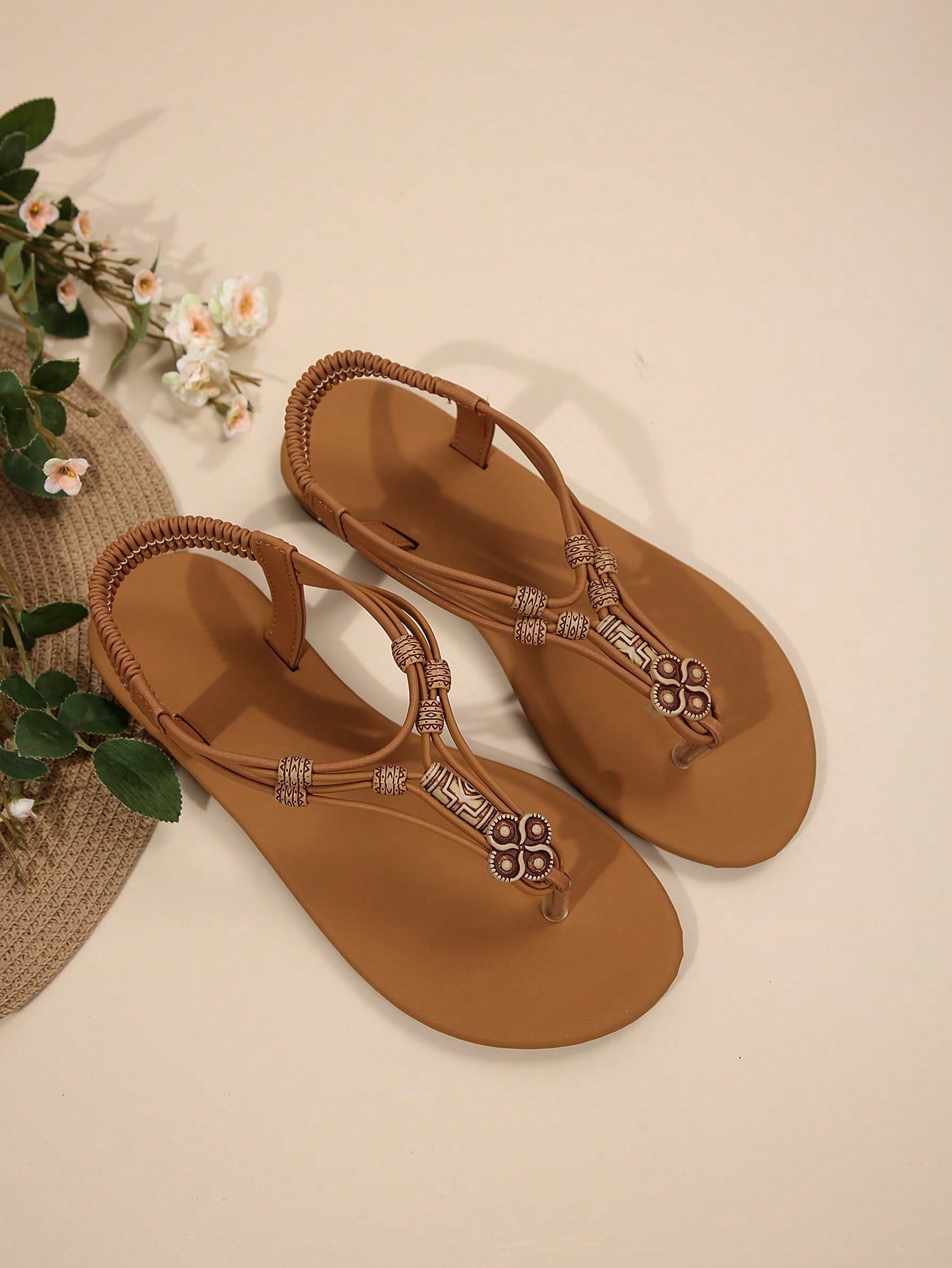Women's flat gladiator sandals with beaded toe ring and toe post, designed for beach and vacation outfits.