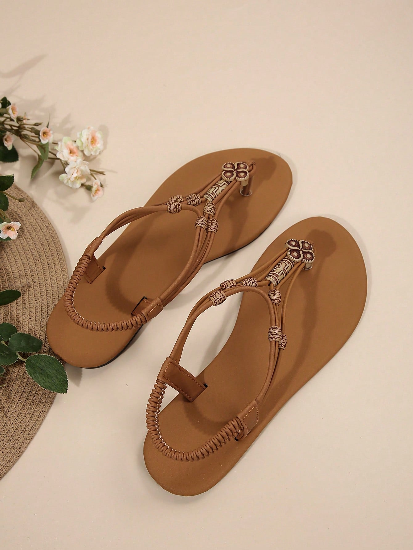 Women's flat gladiator sandals with beaded toe ring and toe post, designed for beach and vacation outfits.