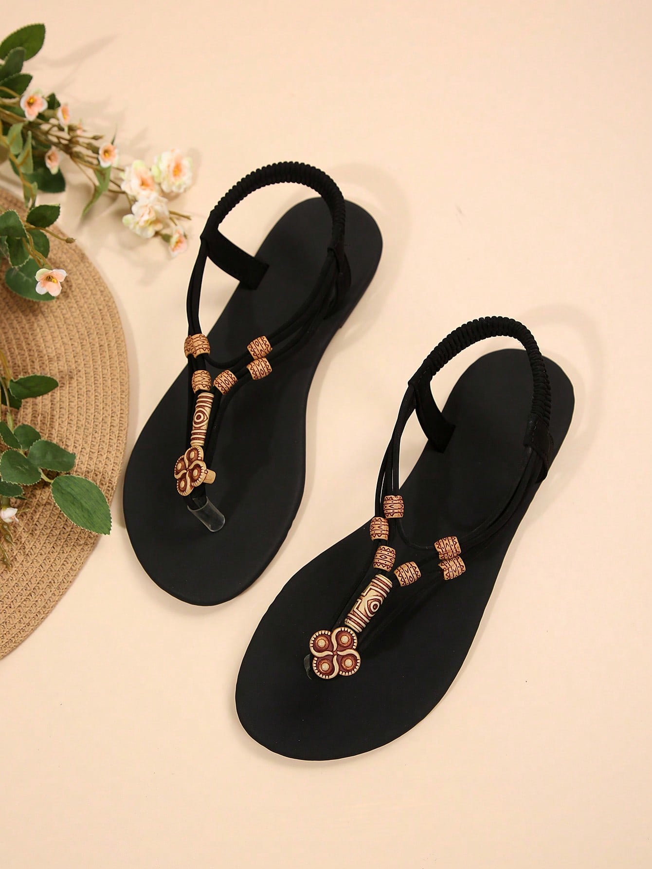 Women's flat gladiator sandals with beaded toe ring and toe post, designed for beach and vacation outfits.
