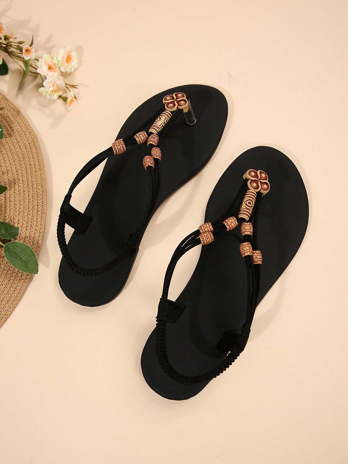 Women's flat gladiator sandals with beaded toe ring and toe post, designed for beach and vacation outfits.