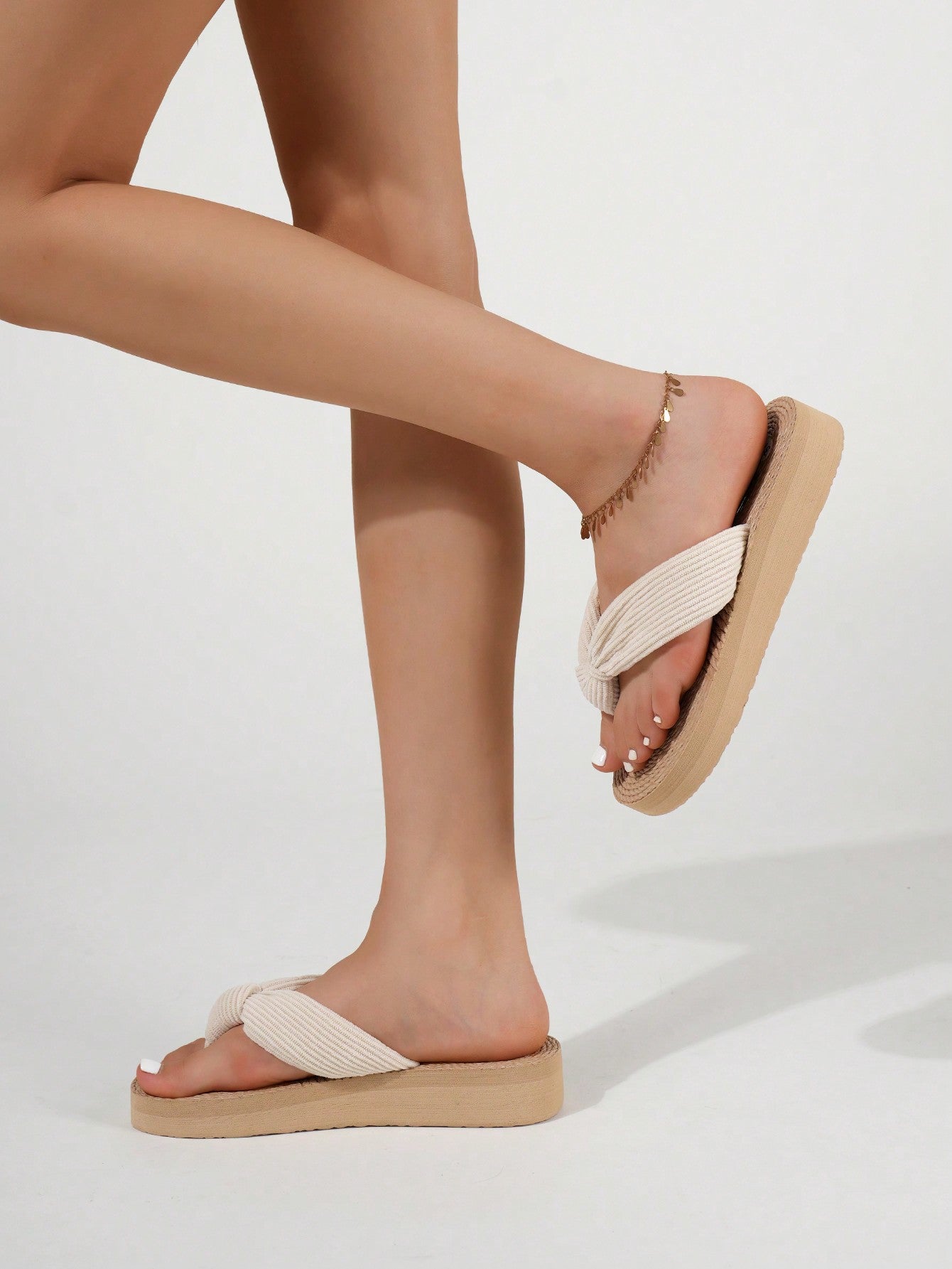 Women's wedge flip flops with braided thong strap, low heel, and thick sole in a casual minimalist outdoor style.