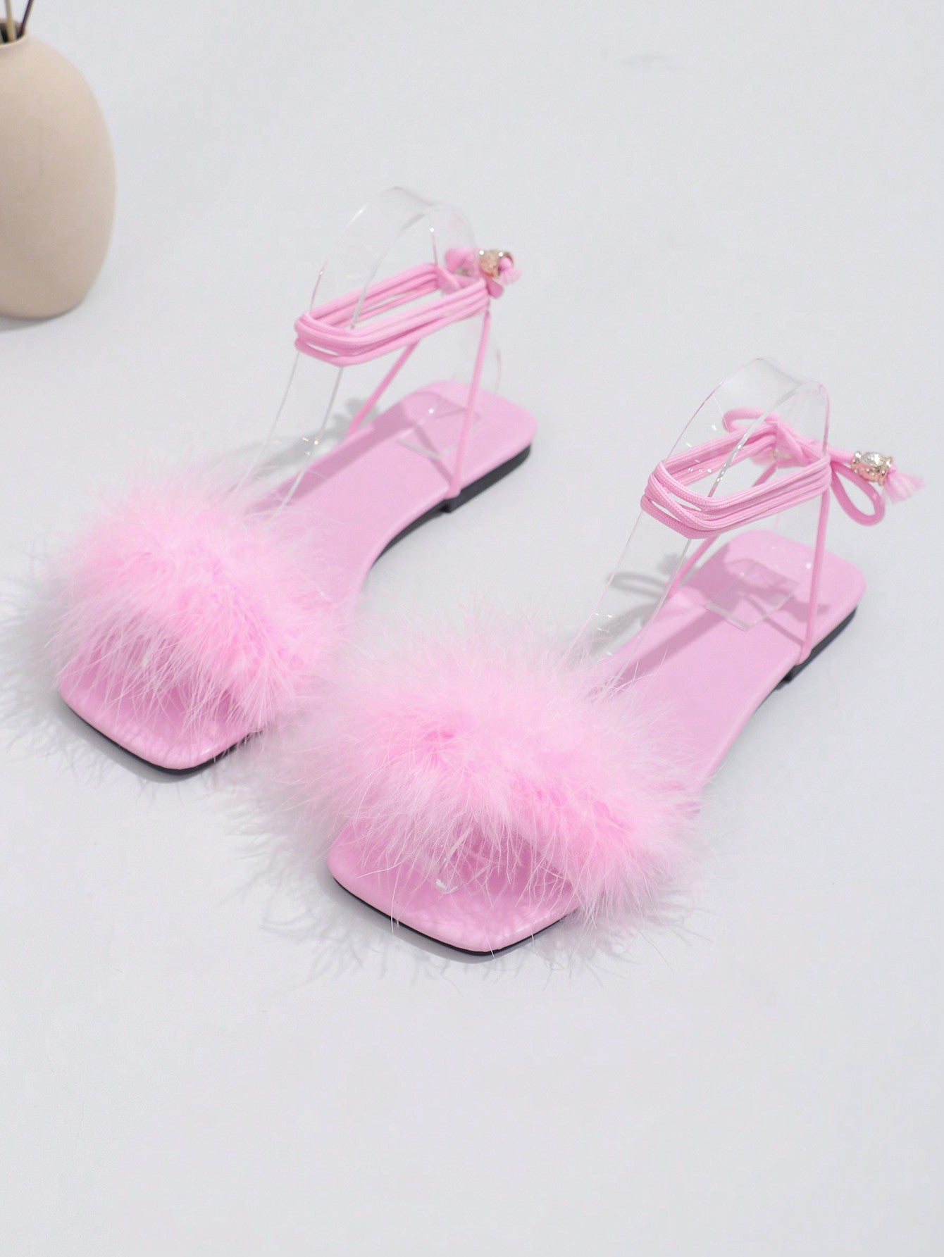 Women's flat strappy sandals with bow detail, open toe, and Roman-style criss-cross lace-up design in an elegant look.