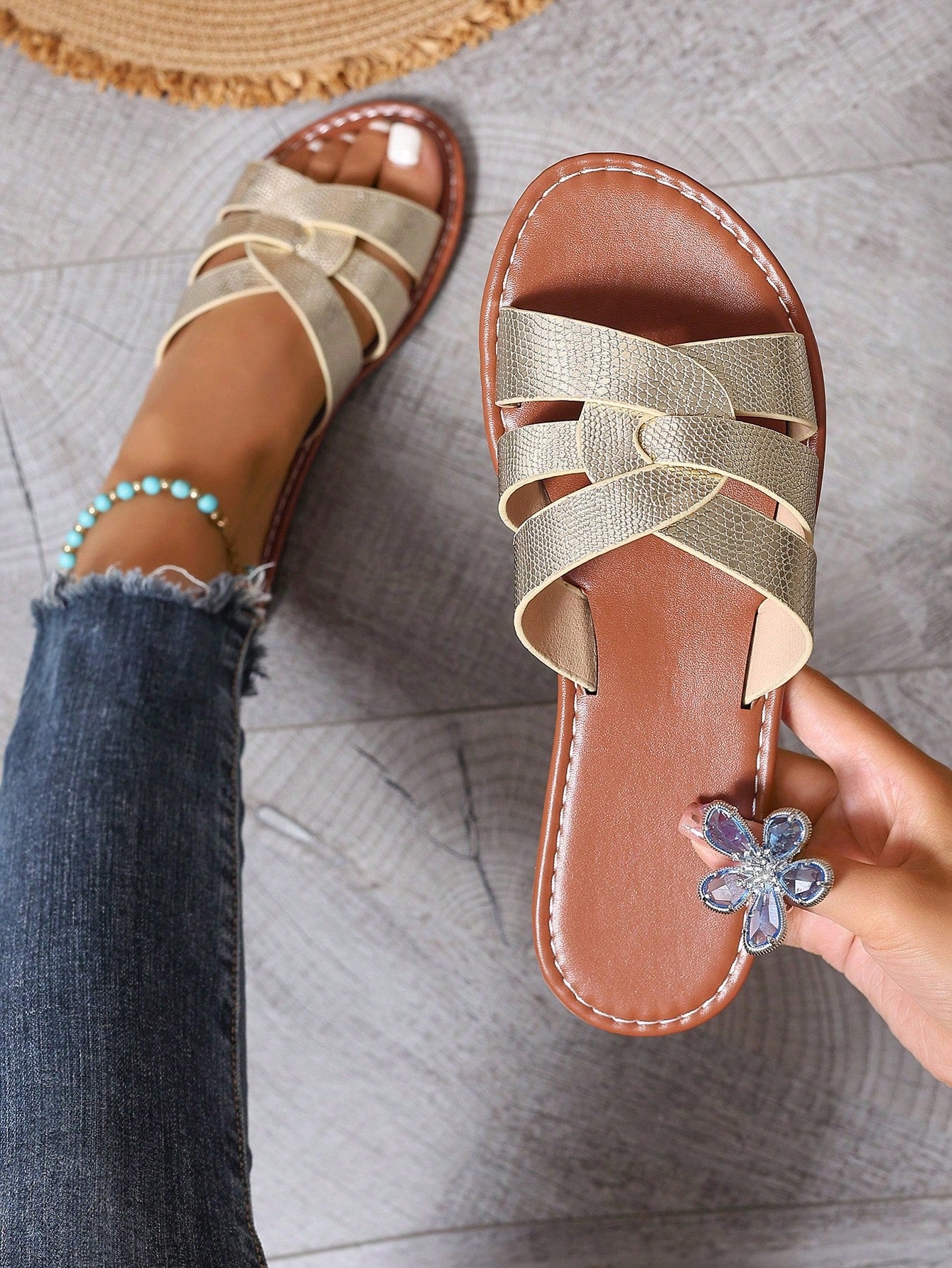 Pair of women’s open-toe flat slide sandals with an H-shaped strap, braided and embossed details, and a minimalist slip-on design suitable for casual outdoor wear.